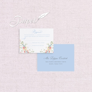 May include: A light blue RSVP card with a floral design and the text "Response" in a cursive font. The card includes the text "We have reserved seats in your honour. Kindly reply before the thirtieth of March." and has two lines for the guest to indicate whether they will attend or regretfully decline. The card also includes a light blue address card with the text "Mrs. Delyssa Comstock, 5824 North Greenbelt Drive, Klein, Texas 77379."