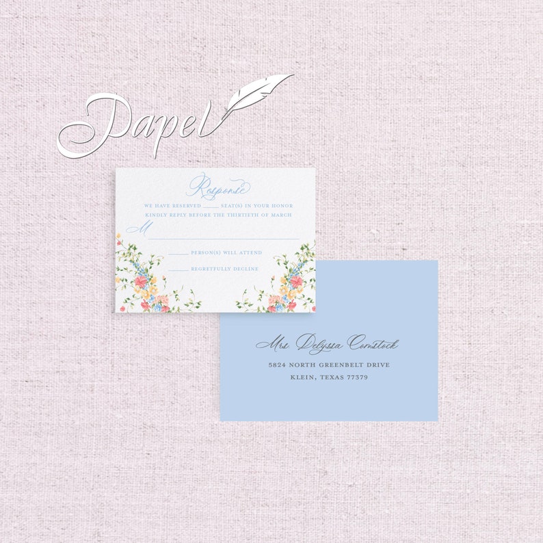 May include: A light blue RSVP card with a floral design and the text "Response" in a cursive font. The card includes the text "We have reserved seats in your honour. Kindly reply before the thirtieth of March." and has two lines for the guest to indicate whether they will attend or regretfully decline. The card also includes a light blue address card with the text "Mrs. Delyssa Comstock, 5824 North Greenbelt Drive, Klein, Texas 77379."