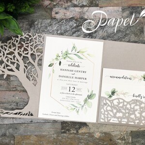May include: A wedding invitation with a laser cut tree design. The invitation is printed on a light brown cardstock and features a watercolor floral design with greenery. The text on the invitation reads "Please join us to celebrate Hannah Gentry and Danielle Harper as they join their lives in marriage Saturday June 12, 2021 at five o'clock in the afternoon Chlo Vuta 214 East Villa Street Horseshoe Bay, Texas Formal Attire Cocktail, Dinner and Dancing to follow"