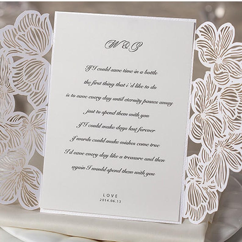 May include: White wedding invitation with a laser-cut floral design. The invitation features a poem about love and the text "W&B" and "LOVE 2014.06.13".