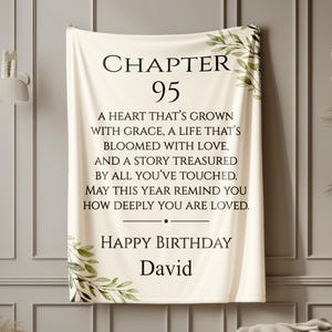 May include: Cream-colored blanket with the text "CHAPTER 95" and a birthday message. The blanket includes a floral design and the name "David". The text reads "A heart that's grown with grace...Happy Birthday".