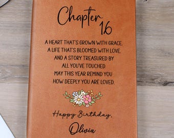 Puede incluir: Un diario de cuero marrón con el texto "Chapter 16" y un diseño floral. El diario incluye el texto "Happy Birthday, Olivia" y un mensaje sincero. Un regalo de cumpleaños reflexivo.