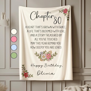 May include: A cream-colored blanket with the text "Chapter 80" and a floral design. The blanket includes the phrases "A heart that's grown with grace" and "Happy Birthday, Olivia."