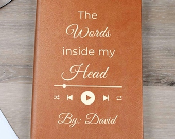 May include: A brown leather journal with the text "The Words inside my Head" and a play button graphic. The text "By: David" is also on the journal.