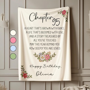 May include: Cream-colored blanket with the text "Chapter 95" and a birthday message. Floral accents in pink, red, and white decorate the corners and center. The blanket includes the name "Olivia".