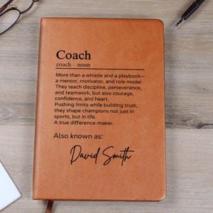 May include: A brown leather journal with the word "Coach" defined as a mentor, motivator, and role model. The text also says "Also known as: David Smith".
