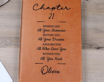 Może przedstawiać: Brązowy skórzany notatnik z napisem "Chapter 21" i inspirującymi cytatami. Imię "Olivia" jest również wygrawerowane na okładce. Widoczna jest zakładka.