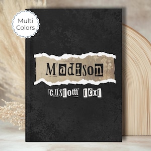 May include: Black journal with the name "Madison" in bold letters on a torn paper design. The words "custom text" are below the name. A "Multi Colors" sticker is in the upper left corner.