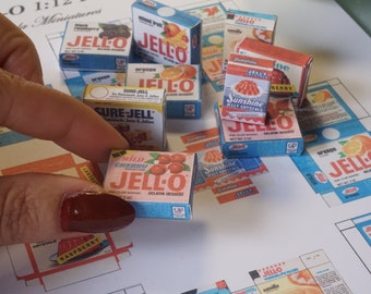 May include: A collection of miniature boxes of Jell-O gelatin dessert mix, including flavors like Wild Cherry, Orange, and Raspberry. The boxes are in various sizes and feature vintage-style packaging with bright colors and illustrations.