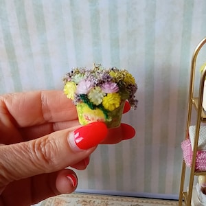Puede incluir: Una maceta de flores amarilla en miniatura con una variedad de flores coloridas, incluyendo amarillas, rosas y moradas.