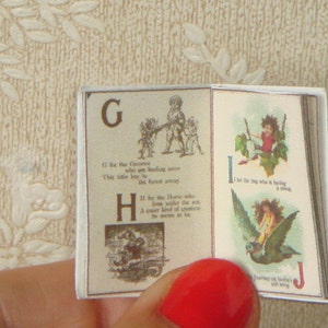 May include: A vintage children's book with illustrations and rhymes for the letters G, H, I, and J. The book is open to pages G and I. The illustrations are colourful and whimsical.