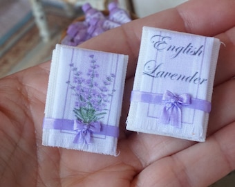 May include: Two miniature white towels with purple ribbon bows. One towel has a lavender floral print and the other says "English Lavender" in black text.