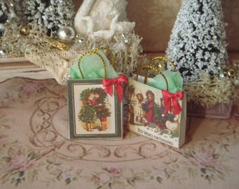 May include: Two miniature gift bags with gold handles and green tissue paper. The bags are decorated with Christmas scenes and the text "Best Wishes for Christmas".
