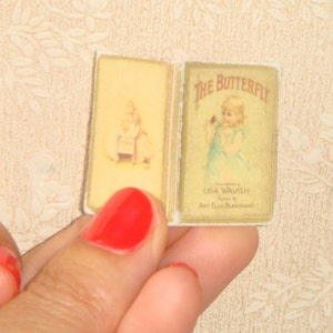 May include: A vintage children's book titled "The Butterfly" with illustrations of a girl and a butterfly. The book cover is yellow with black text and illustrations.