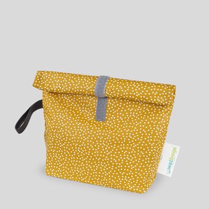 Könnte beinhalten: Eine gelbe Lunch-Tasche mit weißen Punkten und einem grauen Riemen. Die Tasche hat einen Rollverschluss und einen schwarzen Griff. Die Tasche hat ein Etikett mit der Aufschrift "wetbags".