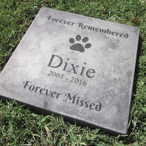 May include: A gray concrete memorial stone with the text "Forever Remembered", a paw print, "Dixie", "2003-2016", and "Forever Missed".
