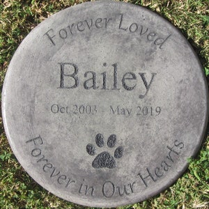 以下が含まれることがあります： 「Forever Loved Bailey Oct 2003 - May 2019 Forever in Our Hearts」と肉球の跡が刻まれた灰色のコンクリート製の記念石です。