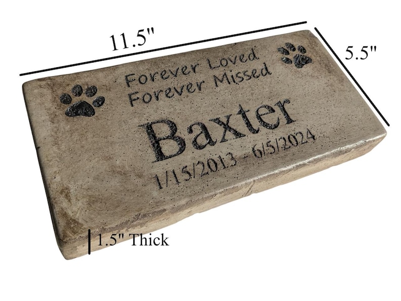May include: A rectangular, light brown, concrete pet memorial stone with rounded edges. It features the text "Forever Loved Forever Missed" and the name "Baxter" with paw prints and the dates "1/15/2013 - 6/5/2024". The stone measures 11.5 inches long, 5.5 inches wide, and 1.5 inches thick.