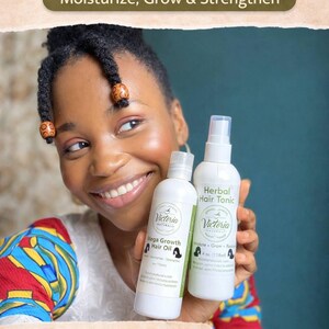May include: A woman smiles, holding two white bottles of Victoria Naturals hair care products. One is Mega Growth Hair Oil, the other Herbal Hair Tonic. The image includes text: "Moisturize, Grow & Strengthen" and "Crafted in small batches, Botanical ingredients."