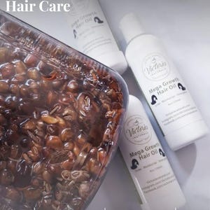 May include: Image of Ayurvedic hair care products. The image features three white bottles of "Mega Growth Hair Oil" and a clear container filled with brown seeds. Text on the bottles includes "Grow, Moisturize, Strengthen". The text "Ayurvedic Hair Oil | Natural Growth & Strong Hair Care" is at the top.