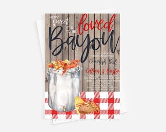 May include: A rustic wooden background with a red and white checkered tablecloth. A large metal pot with a lid is filled with crawfish and corn on the cob. The text "How sweet it is to be loved Bayou" is written in black and red on the wooden background. The text "Join us for a couples shower Crowfish Boil" is written in black and red on the wooden background. The text "Collsen & Baylon April 20, 2024 at 6:00 pm The Barnyard Bar and Grill 19900 Blankenbaker Pwky Austin, TX 89901 RSVP to Nola Lou Lou Registered at Target, Amazon, and Bed Bath & Beyond" is written in black and red on the wooden background.