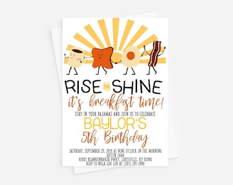 May include: A yellow and orange breakfast themed birthday invitation with a cartoon sun and breakfast foods. The text reads "Rise and Shine it's breakfast time! Stay in your pajamas and join us to celebrate Baylor's 5th Birthday. Saturday, September 29, 2019 at nine o'clock in the morning. Austin Java 92001 Blankenbaker Pkwy, Louisville, KY 92990. RSVP to Nola Lou Lou at (281) 291-2990."