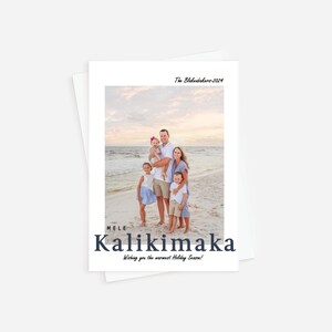 May include: A white holiday card featuring a family photo on a beach. The card includes the text "The Blakesbehrs-2024" at the top and "MELE Kalikimaka Wishing you the warmest Holiday Season!" at the bottom. The family is standing on the beach.