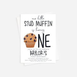 May include: A white invitation card with a cartoon blueberry muffin and the text "our little STUD MUFFIN is turning ONE". The invitation is for Baylor's first birthday party on December 15, 2025, at 11:00 AM. The address is 8990 Owala Lane, Brooklyn, NY 91990. RSVP to Nola Lou Lou.