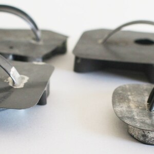 May include: Four vintage metal cookie cutters with handles. The cutters are shaped like a heart, a circle, a star, and a flower. The cutters are made of dark gray metal and have a rustic look.