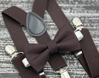 May include: Brown suspenders with a brown bow tie. The suspenders have adjustable clips and a leather strap.