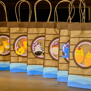 May include: Six brown paper gift bags with animal-themed cutouts. Each bag features a different animal, including a tiger, lion, zebra, monkey, elephant, and giraffe. The bags have light blue wave accents and brown handles.