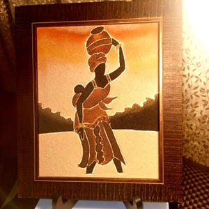 Arte africano de madre e hijo en arena – Gorée, Senegal. Cuadro enmarcado.