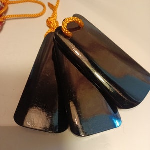May include: Three black wooden clappers with a yellow cord attached. The clappers are tied together at the top.