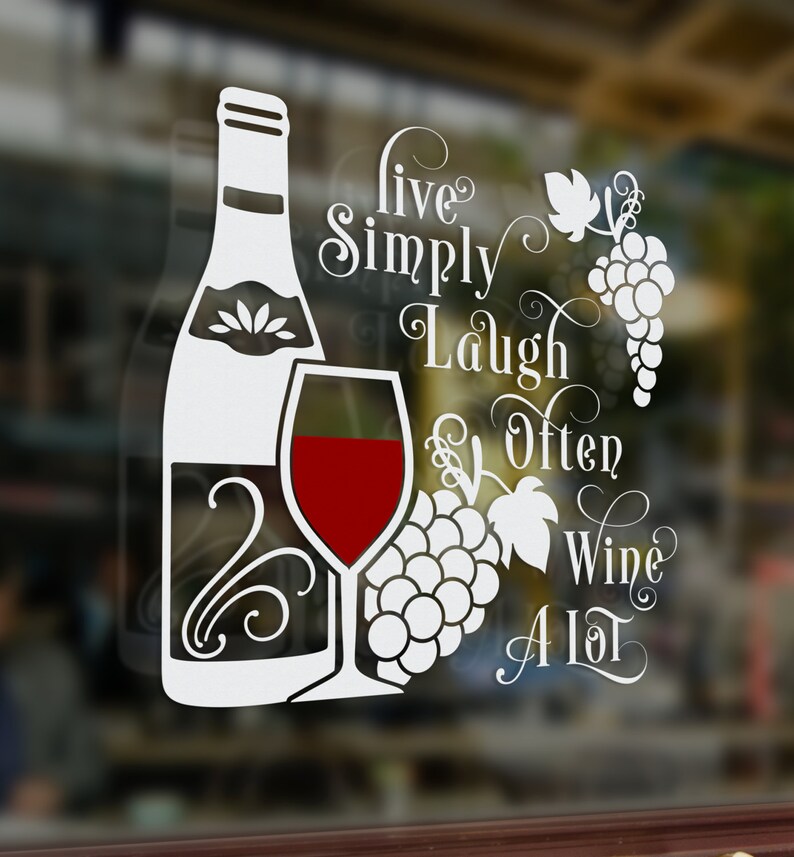 May include: White vinyl decal with a wine bottle, glass of wine, and grapes. The text reads "Live Simply Laugh Often Wine A Lot".
