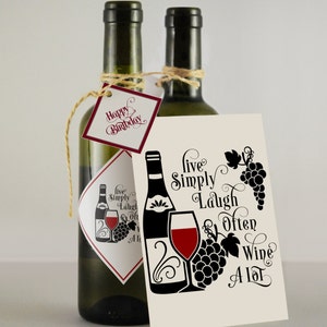 May include: Two bottles of wine with a gift tag that says "Happy Birthday". The gift tag is tied to the bottle with twine. A card with the text "Live Simply Laugh Often Wine A Lot" is in front of the bottles. The card has a black and white illustration of a wine bottle, a wine glass, and grapes.