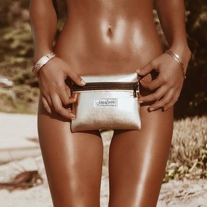May include: A gold metallic fanny pack with a black zipper and the text "NeoLove" printed on the front.