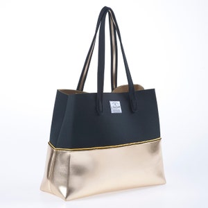 May include: A black and gold tote bag with a yellow trim and the word "Lovemore" printed on the front.