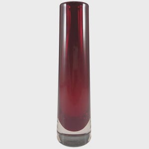 May include: A slender, ruby-red vase. The vase is cylindrical, with a clear glass base. The smooth, glossy surface reflects light. The design is simple yet sophisticated, making it a decorative piece for any home. The vase is approximately 30 cm tall.