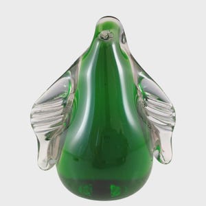May include: A handcrafted glass sculpture in the shape of a bird. The sculpture features a vibrant green body and clear, wing-like extensions. The glass has a glossy finish, reflecting light and adding depth to the design. The sculpture is a decorative art piece.