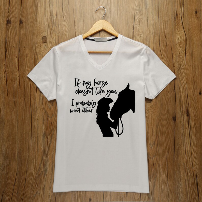 May include: White t-shirt with a black silhouette of a woman and a horse. The text reads "If my horse doesn't like you I probably won't either."