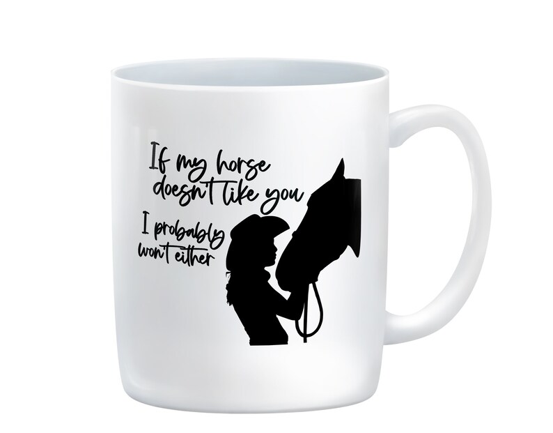 May include: White ceramic mug with a black silhouette of a horse and a person wearing a cowboy hat. The text on the mug reads "If my horse doesn't like you, I probably won't either."