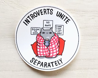 Puede incluir: Una pegatina redonda blanca con un contorno negro y el texto "Introvertidos Uníos Separadamente". Un gato gris de dibujos animados está en el centro de la pegatina, con una manta a cuadros rojos y blancos y sosteniendo una taza. El gato está rodeado de cuatro carteles que dicen "Go Away", "Room One", "I Came I Saw I Left Early", y "I Came I Saw I Left Early".