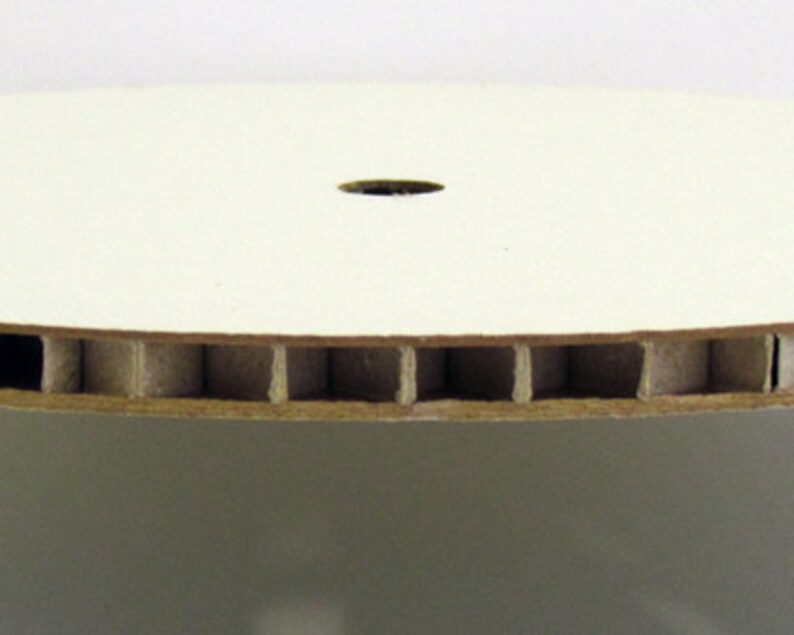 Peut inclure: Un disque en carton blanc avec un trou au centre. Le bord du disque est en carton ondul&eacute;.