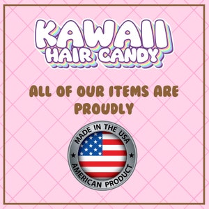 May include: A square graphic with a light pink background featuring a grid pattern. The text reads KAWAII HAIR CANDY in white with a rainbow outline. Below, brown text states ALL OF OUR ITEMS ARE PROUDLY. A circular silver badge displays the USA flag.