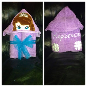 May include: Purple hooded towel with a princess character embroidered on the hood and the name "KADENCE" embroidered on the front.
