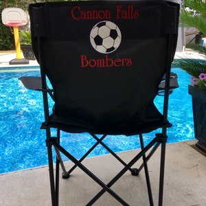 Pu&ograve; includere: Sedia pieghevole nera con seduta e schienale in tessuto nero. Lo schienale della sedia &egrave; decorato con un pallone da calcio bianco e un testo ricamato in rosso che dice "Cannon Falls Bombers".