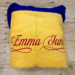 May include: Yellow fleece blanket with a blue border and red embroidered text that says "Emma June".