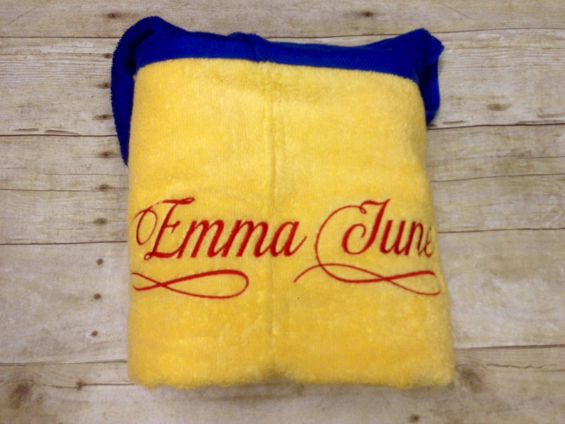 May include: Yellow fleece blanket with a blue border and red embroidered text that says "Emma June".