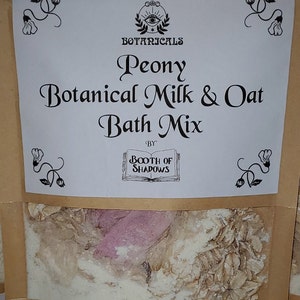 May include: A brown paper bag with a white label that reads "Sacred Botanicals Peony Botanical Milk & Oat Bath Mix by Booth of Shadows". The bag contains a white bath mix with pink and brown accents.