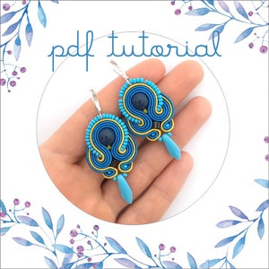May include: A pair of blue and gold earrings with a dark blue bead in the center. The earrings are made with a technique called peyote stitch. The earrings are hanging from silver hooks. The image includes the text "pdf tutorial".